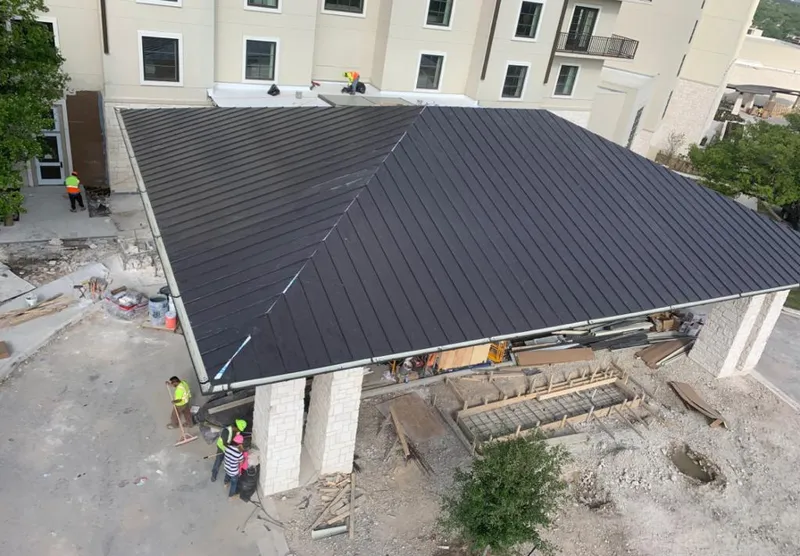 Metal roofing installation team working on a commercial building in Commerce